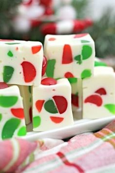 white chocolate with green and red designs on it sitting on a plate next to candy canes