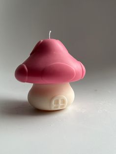 a small pink candle sitting on top of a white table