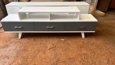 a white and grey tv stand with drawers