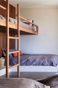 two bunk beds in a room with wooden walls