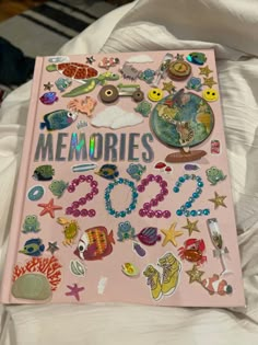 a pink book with lots of stickers on the cover and words that spell out memories