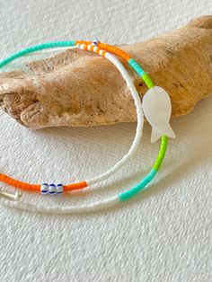 - Dive into the spirit of the seashore with our bohemian Miyuki bead double wrap bracelet, a perfect complement to your beach day ensemble. This handcrafted piece is adorned with a charming fish-shaped shell bead, evoking the playful essence of the ocean. The vibrant mix of orange, turquoise, white, and green beads, along with eye-catching striped Czech glass beads, captures the lively colours of the coastline. - Designed for versatility and style, our bracelet can be effortlessly wrapped around your wrist twice, offering a snug and comfortable fit. It's an ideal stand-alone statement piece or a dynamic addition to a layered bracelet look - an 'arm party' that celebrates your love for beach aesthetics. - Whether you're strolling along the sand or wishing for a piece of the beach to accompa Miyuki Bead, Orange Turquoise, Double Wrap Bracelet, Arm Party, Green Beads, Fish Shapes, Miyuki Beads, Beach Inspired, Shell Beads