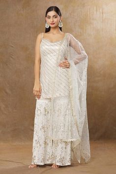 Ivory kurta with all over embroidery using sitara and sequin work. Paired with a floral embroidered sharara and dupatta. - Aza Fashions White Sleeveless Festive Sharara, Festive Sleeveless White Sharara, White Sleeveless Sharara For Festive Occasion, White Sleeveless Set For Diwali, Kurta And Sharara, Embroidered Sharara, All Over Embroidery, Women Kurta, Straight Kurta