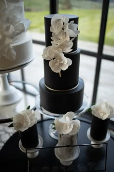 a black and white wedding cake with flowers on it