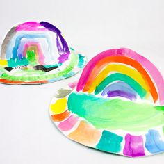 two paper plates painted with rainbows on them