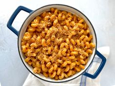 a bowl filled with macaroni and cheese on top of a white tablecloth