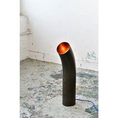 a metal pipe sitting on top of a floor next to a wall