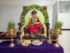 there is a statue in the middle of a purple table with gold dishes on it