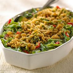 a casserole dish filled with green beans and red pepper crumbs on top