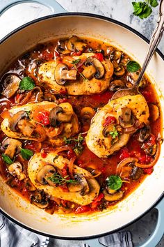 a pan filled with chicken, mushrooms and tomato sauce on top of a marble counter