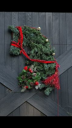 a christmas wreath on the side of a barn door