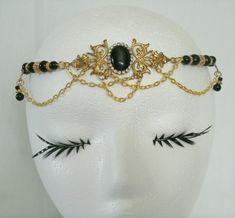 "This beautiful circlet has black glass beads, gold plated accent beads, gold plated chain, brass side accent pieces, brass pendant and black cats eye stone setting with rhinestones. 20\" long can be adjusted to 24\". Lobster clasp." Elegant Handmade Gold Body Jewelry, Elegant Adjustable Body Jewelry For Festivals, Elegant Gold Brass Body Jewelry, Elegant Gold Body Jewelry For Festivals, Steampunk Black Headpieces For Masquerade, Adjustable Gold Beaded Body Jewelry, Elegant Black Body Jewelry For Evening, Gothic Gold Necklace For Wedding, Gold Gothic Necklace For Wedding