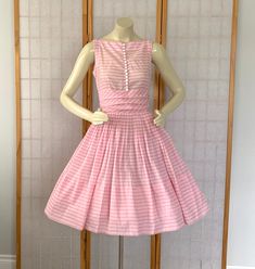 Vintage 1950s Early 60s Pink Peppermint Cupcake Bombshell Pin Up Rockabilly Dress.   1950s Barbie Doll Style Dress Pink peppermint stripe cotton party dress Nipped waist Full Gathered skirt White buttons on bodice Horizontal pleats at the waist Pink metal zipper in back Ties on the side to form bow in back Very wide hem Label: JONATHAN LOGAN In fabulous vintage condition --absolutely fabulous for it's age!! one little mark on the side and on tiny dot in back shown in last 2 photos--may wash out Vintage Sleeveless Dress For Tea Party, Spring Retro Petticoat, 1950s Style Pink Vintage Dress, 1950s Style Vintage Dress For Garden Party, Vintage Pink Petticoat For Party, Pink Vintage Petticoat For Parties, 1950s Barbie, Cotton Party Dress, Full Gathered Skirt