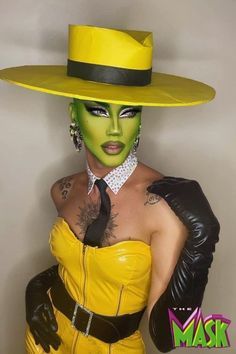 a woman with green makeup wearing a yellow hat