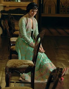 Indulge in timeless elegance with this classic kalidar anarkali set, crafted from firozi green jacquard silk banarasi. Featuring intricate zari and zardozi embroidery, enhanced with dabka, sequins, and pearls for added depth and richness, this design is truly captivating. The ensemble is completed with a cropped jacket adorned with sequins and delicate pearl tassels, while a signature embellished belt ensures a gracefully defined silhouette. Green Chanderi Bandhgala With Cutdana, Festive Green Chanderi Bandhgala, Traditional Anarkali Set With Cutdana And Front Open Design, Traditional Front Open Anarkali Set With Cutdana, Green Chanderi Bandhgala With Traditional Drape, Green Semi-stitched Bandhgala With Resham Embroidery, Anarkali Style Bandhgala With Resham Embroidery, Green Chanderi Bandhgala With Zari Work, Pista Green Chanderi Bandhgala With Zari Work