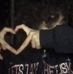 a person making a heart with their hands