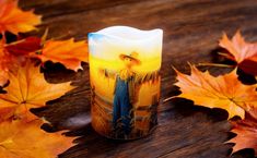 a candle sitting on top of a wooden table surrounded by leaves and autumn foliages