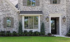 a brick house with white trim and windows