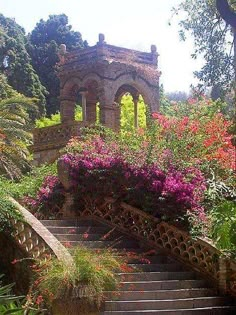 the stairs lead up to an old building with flowers growing on it's sides