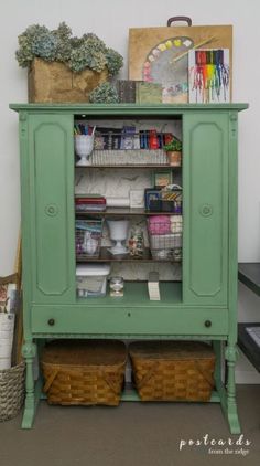 a green cabinet with baskets and books on top