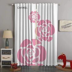 a child's room with a rocking horse and pink roses on the curtain panels