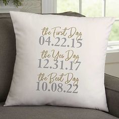 a white pillow with the date and time printed on it, sitting on a couch