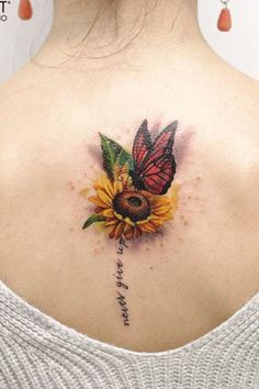 a woman with a butterfly tattoo on her upper back shoulder and sunflower in the center