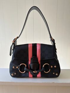 This Gucci GG Web Horsebit Hobo is crafted from Guccissima monogram black fabric with rose gold tone hardware, has a leather shoulder strap and pink web detailing. Canvas lining with zipper pocket and push through closure at front. Measuring: 10 in. L, 8 in. H, 2.75 in. D. Good condition: Note: See last 2 photos for discoloration on some areas of web detail. Scratching at studs. Web Detail, 2 Photos, Black Fabric, Zipper Pocket, Fendi, Shoulder Strap, Dior, Chanel, Louis Vuitton