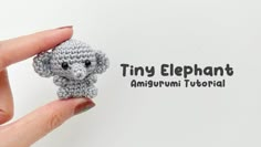 a tiny crocheted elephant sitting on top of someone's finger with the words tiny elephant in front of it