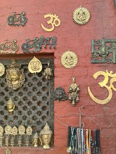 there are many different items on the wall in front of this door that is decorated with gold and silver