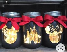 three mason jars with lights in them and a red bow on the top one is decorated like a castle