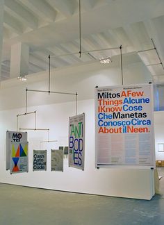 an art gallery with posters hanging from the ceiling