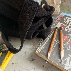 two pencils sitting on top of a book next to a pair of sharpeners