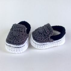 a pair of crocheted shoes sitting on top of a white table