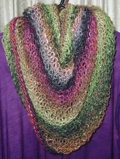 a multicolored crocheted scarf hanging from a hook