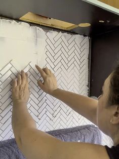 a woman is working on a tile wall