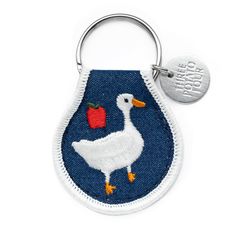 an embroidered key chain with a duck and apple on it