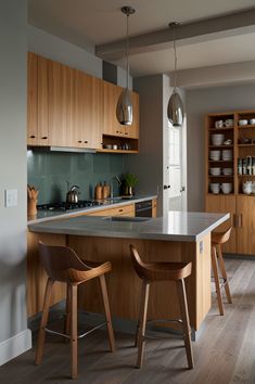 a modern kitchen with wooden cabinets and counter tops, along with two bar stools