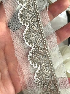 Silver Sequence Ribbon with Zari & Crystal - 3cm Indian Embroidery Lace by Yard 🌟 Add a touch of glamour to your creations with our Silver Sequence Ribbon. Featuring intricate zari work and sparkling crystals, this 3cm wide ribbon is perfect for enhancing saris, lehengas, gowns, and dresses. The elegant design on net fabric offers a sophisticated finish to any project ✨💫. Materials: Silver Sequins ✨ Zari Embroidery 🌟 Crystal Accents 💎 Net Fabric Base 🌸 Uses: Saris & Lehengas: Ideal for addi Sari Lehenga, Lehenga Gown, Zari Embroidery, Indian Embroidery, Net Fabric, Zari Work, Embroidery Lace, Gown Dress, Ribbon Trim