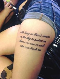 a woman with a tattoo on her thigh that reads, god long as there's someone in the sky to protect me