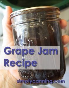 a person holding a jar filled with purple jam and text overlay reads grape jam recipe