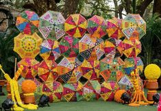 colorfully decorated umbrellas are on display in the grass near potted plants and other decorations