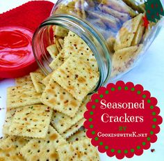 some crackers are in a glass jar and on the table is a red heart