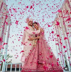 two people are posing for a photo in front of rose petals and confetti