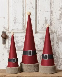 three red gnome hats sitting on top of a wooden table