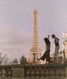 two people standing in front of the eiffel tower