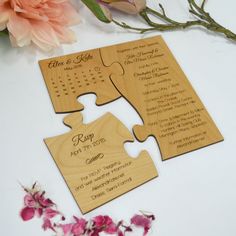 two wooden puzzle pieces with the names and date on them, sitting next to flowers