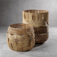 two woven baskets sitting next to each other on top of a cement flooring area