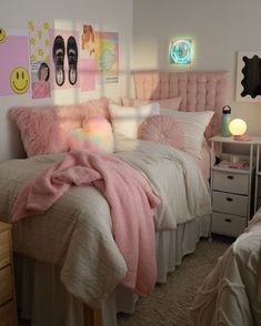 a bedroom with pink bedding and pictures on the wall above it, along with two nightstands