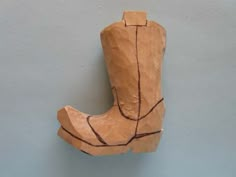 a piece of wood that has been carved into the shape of a boot on a wall